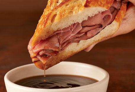 Sourdough French Dip with roast beef on a sourdough baguette dipped in au jus