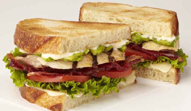 Toasted Chicken Club sandwich with bacon, tomato and avocado on toasted sourdough