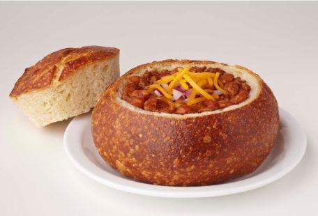 Beef chili with cheddar cheese and onions in a sourdough bread bowl