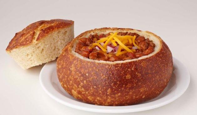 Beef chili with cheddar cheese and onions in a sourdough bread bowl