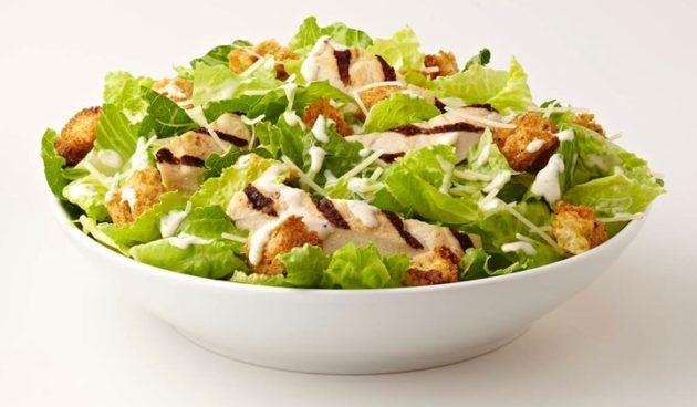 Caesar Salad with chicken, sourdough croutons and Parmesan cheese in a bowl