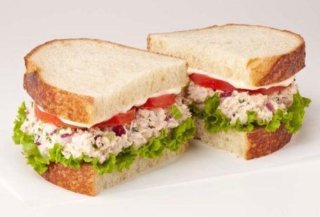 Tuna Salad Sandwich with celery, red onion, parsley, tomatoes, lettuce and mayo on sliced sourdough