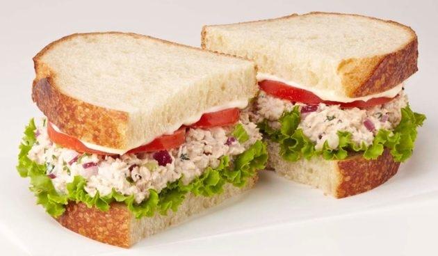 Tuna Salad Sandwich with celery, red onion, parsley, tomatoes, lettuce and mayo on sliced sourdough