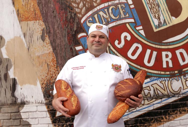 Fernando Padilla outside 10th Avenue Bakery holding bread