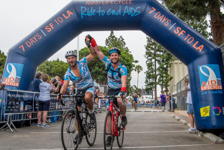 Aids Life Cycle Riders crossing the finish line and linking hands