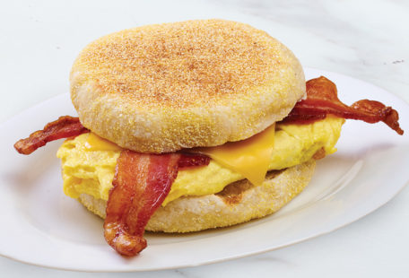 Bacon & Cheddar on English Muffin Breakfast Sandwich on marble counter